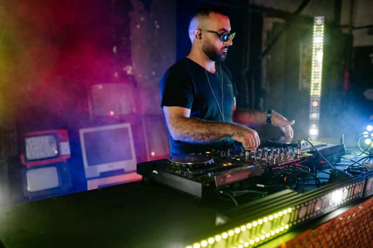 DJ in action with vivid lights creating a vibrant nightlife experience at a club event.